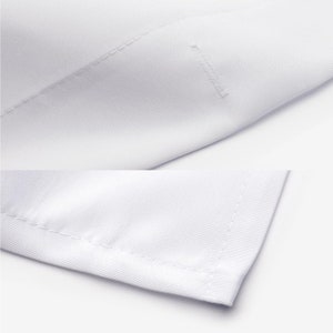 May include: Close-up of a white fabric with a stitched seam. The fabric is smooth and has a subtle texture.