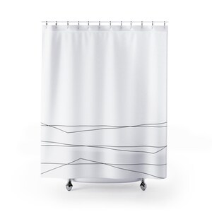 May include: White shower curtain with a black abstract line design. The lines are thin and create a geometric pattern at the bottom of the curtain.