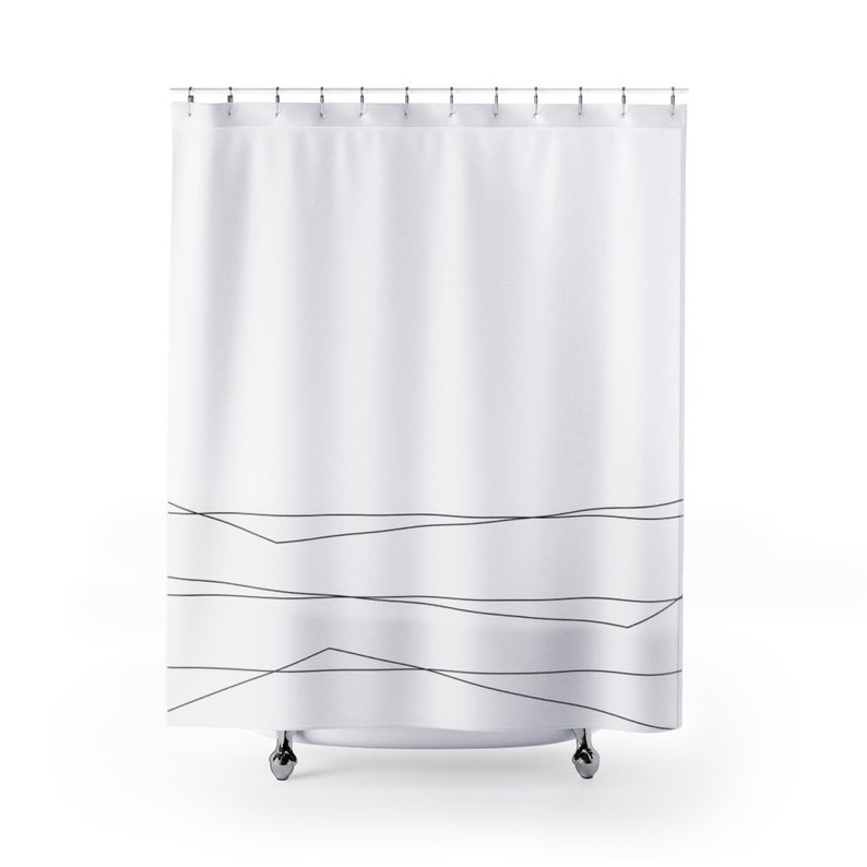 May include: White shower curtain with a black abstract line design. The lines are thin and create a geometric pattern at the bottom of the curtain.
