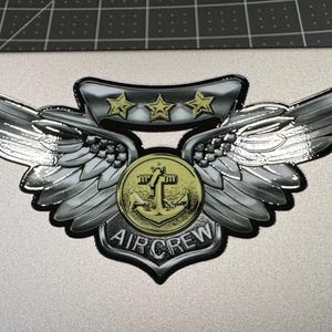 May include: A silver aircrew patch with three gold stars, a gold anchor, and the text "AIRCREW".