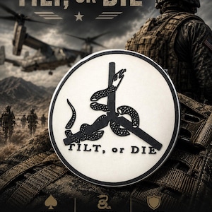 May include: A circular patch featuring a white background with a black border and a black graphic of a snake coiled around a three-bladed rotor. The text TILT, OR DIE is printed in black on the patch. The design includes tactical imagery.