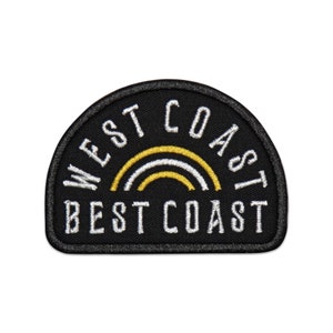 May include: Black embroidered patch with a white outline. The patch is shaped like a half circle and features a white and gold rainbow with the text "West Coast Best Coast" in white.