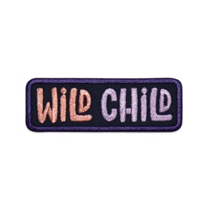 May include: A black rectangular patch with the words "WILD CHILD" embroidered in pink and orange.