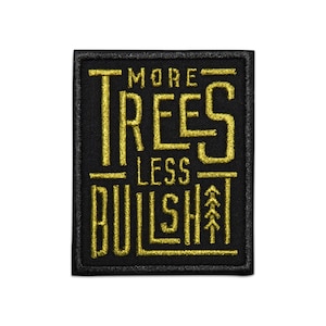 May include: Black and gold embroidered patch with the text "More Trees Less Bullshit" and a stylized tree graphic.