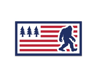 May include: A blue silhouette of Bigfoot walking in front of an American flag with four pine trees on the left side. The flag is red, white, and blue.