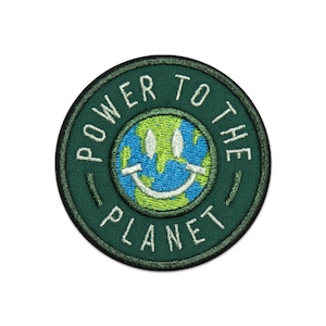May include: Green embroidered patch with the text "Power to the Planet" in white lettering around a green and blue smiley face earth icon.