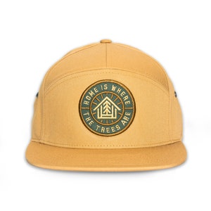 May include: A tan 5-panel baseball cap with a green and yellow embroidered patch that says "Home is where the trees are".