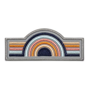 Może przedstawiać: Szara naszywka haftowana z wzorem tęczy. Tęcza składa się z wielu warstw pomarańczowej, różowej, niebieskiej i białej nici. Naszywka idealnie nadaje się do dodania odrobiny fantazji do każdego projektu.