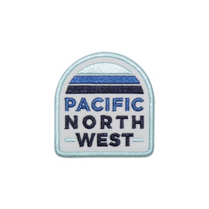 May include: A white, blue, and black embroidered patch with the text "PACIFIC NORTH WEST" in a retro style.