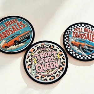 May include: Three round iron-on patches. One patch features a vintage car with the text "Will Brake for Yardsales". Another patch features a vintage car with the text "Will Brake for Yardsales" and a checkered background. The third patch features a leopard print background with the text "Thrift Store Queen" and a crown.