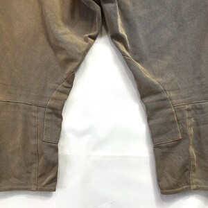 May include: A pair of brown riding breeches with knee patches and a cinched bottom.