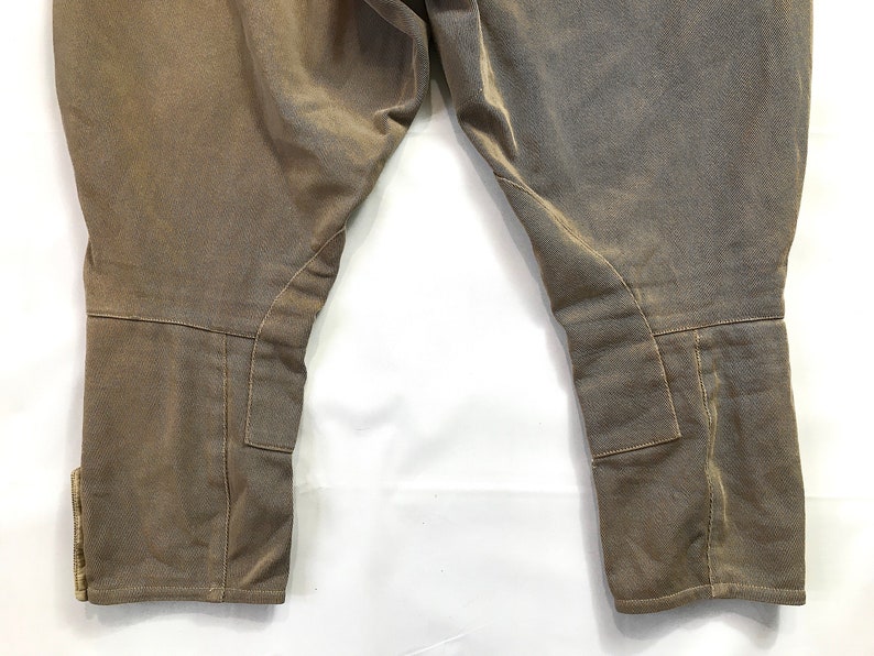 May include: A pair of brown riding breeches with knee patches and a cinched bottom.