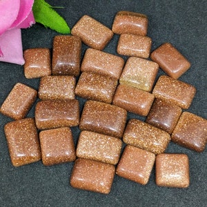 Può includere: Una collezione di 20 pietre di sunstone dorate rettangolari e levigate. Le pietre hanno una texture scintillante e brillante.