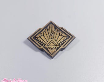 May include: A square, gold-colored pin with a black border. The pin features a stylized design of a building with a sunburst pattern and geometric shapes. The text "Mimi Art Store" is visible in the bottom left corner.