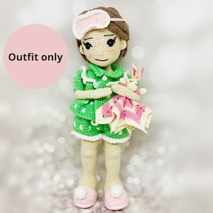 May include: Green and white polka dot pajamas with a white lace trim. The pajamas have a pink and white blanket and a stuffed bunny rabbit.