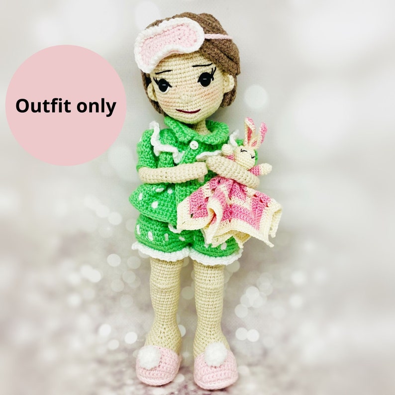 May include: Green and white polka dot pajamas with a white lace trim. The pajamas have a pink and white blanket and a stuffed bunny rabbit.