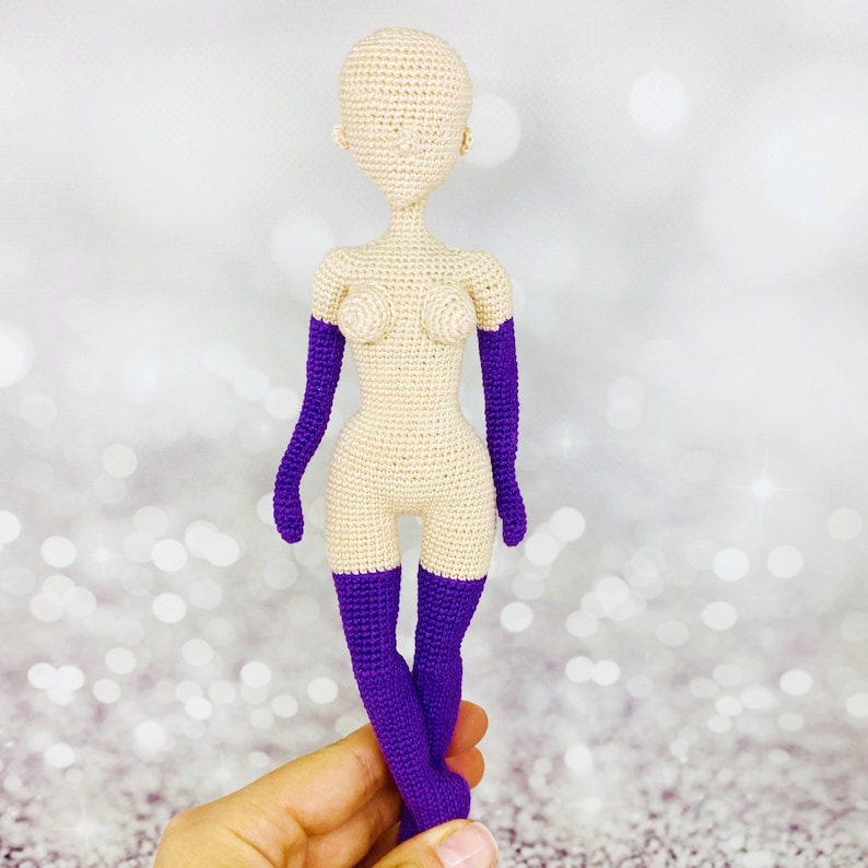 May include: A crocheted doll with a nude body and purple arm warmers and leg warmers.