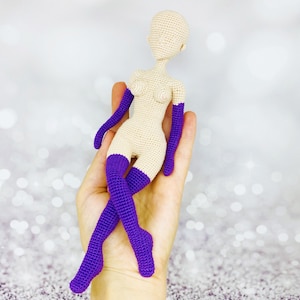 May include: A crocheted doll with a nude body and purple arm warmers and leg warmers.