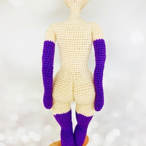 May include: A crocheted doll with a cream-colored body and purple arms and legs.