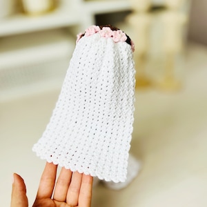 May include: White crocheted bridal veil with a pink flower crown.