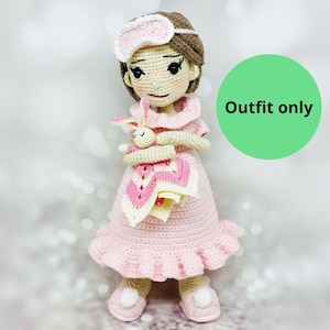 May include: A crocheted doll wearing a pink nightgown and a white eye mask, holding a crocheted bunny. The doll is standing on a white surface. "Outfit only" is written on a green circle in the background.