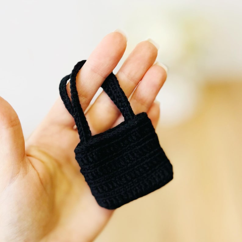 May include: A small black crocheted tote bag with two handles.