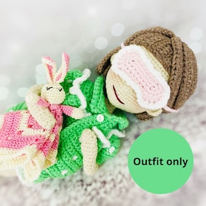 May include: Green and pink crocheted outfit for a doll, featuring a sleep mask and a small crocheted bunny. The outfit is labeled "Outfit only".