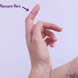 Puede incluir: Primer plano de una mano con un dedo extendido. Una l&iacute;nea negra se dibuja a trav&eacute;s del dedo, con el texto "Medir aqu&iacute;" y una flecha que apunta a la l&iacute;nea.