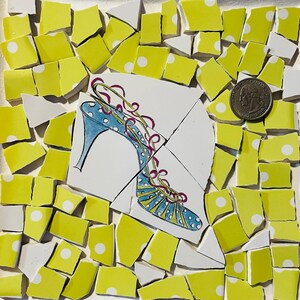 May include: A mosaic art piece featuring a high-heeled shoe design. The shoe is blue with white polka dots and pink ribbon laces. The mosaic is composed of yellow and white tiles with white polka dots, and a U.S. quarter is included for scale.