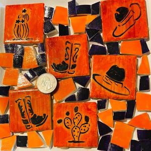 May include: A mosaic art piece featuring five square orange tiles with black line drawings of two cowboy boots, two cacti, and a cowboy hat, surrounded by scattered orange and dark purple tile shards, with a US quarter coin for scale.