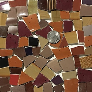 May include: A collection of small, irregular ceramic tiles in shades of brown, red, and tan. The tiles are arranged in a random pattern and are perfect for use in mosaic art projects.