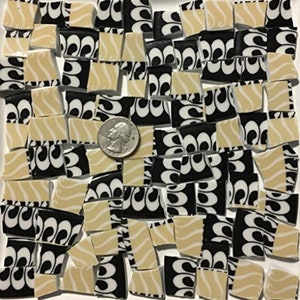 May include: A collection of black and cream mosaic tiles with a swirling pattern. The tiles are irregular in shape and size.