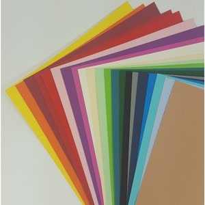 May include: A selection of coloured cardstock paper fanned out to display a range of hues. The paper includes shades of yellow, red, purple, green, and brown. Perfect for crafting, scrapbooking, and other creative projects. Each sheet is a different colour.