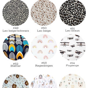 May include: A collection of 10 different fabric swatches with various patterns, including leopard print, leaves, rainbows, airplanes, bears, and woodland animals. The swatches are labeled with numbers and names in German.