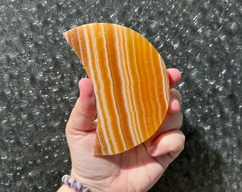 Banded orange calcite crystal crescent moon carving