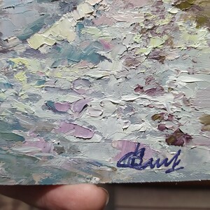 May include: A close-up of a textured, abstract painting in shades of gray, white, and purple. The painting is signed in the bottom right corner with the artist's name "Daryl".