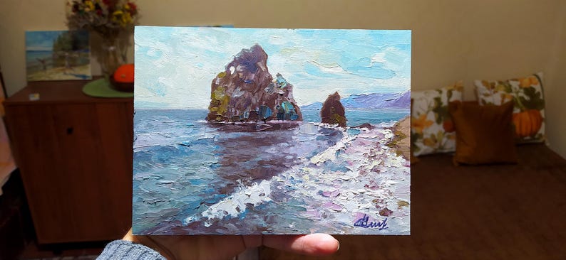 May include: A painting of a seascape with two rocky islands in the distance. The water is a deep blue and the sky is a light blue with white clouds. The painting is done in a loose, impressionistic style.