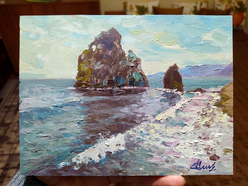 May include: A painting of two rocky cliffs rising from the ocean. The cliffs are brown and gray, and the water is a light blue with white waves. The sky is a light blue with white clouds.