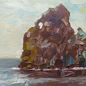 May include: A painting of a rocky island with a blue sky and white clouds in the background. The island is brown and has a rough texture. The water is blue and has white waves.