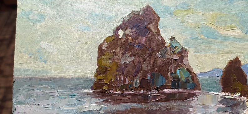 May include: A painting of a rocky island with a blue sky and white clouds in the background. The island is brown and has a rough texture. The water is blue and has white waves.