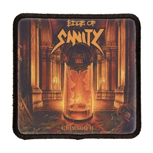 以下が含まれることがあります： 黒と白の刺繍パッチで、「Edge of Sanity」と「Crimson II」というテキストがゴシック体で書かれています。暗いゴシック様式の教会を背景に、ガラスの円筒の中に閉じ込められた炎の図形が描かれています。