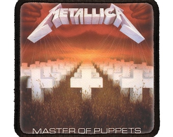 Peut inclure: Un patch noir et blanc avec le nom du groupe "Metallica" en lettres blanches et le titre de l'album "Master of Puppets" en lettres blanches. L'image montre un champ de croix blanches avec un coucher de soleil rouge et orange en arrière-plan.