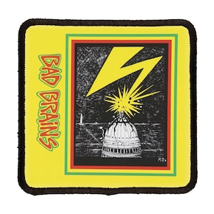Puede incluir: Parche cuadrado amarillo con una imagen en blanco y negro de un rayo que golpea la parte superior del Capitolio de los Estados Unidos. El texto "BAD BRAINS" está en el lado izquierdo del parche.