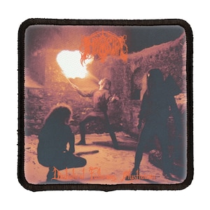 May include: A black and white patch with an image of three figures in a dark, fire-lit room. The band name "Darkthrone" is written in orange at the top of the patch. The text "Transilvanian Hunger" is written in orange at the bottom of the patch.