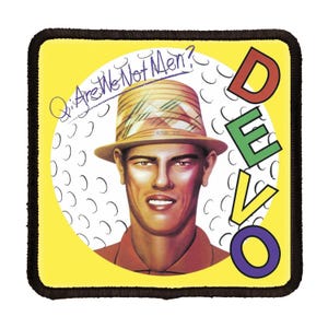 May include: A yellow square patch with a black border. The center of the patch features a white circle with a man wearing a straw hat and a red shirt. The text "Q: Are We Not Men?" is written in black across the top of the circle. The word "DEVO" is written vertically in large letters on the right side of the patch. The letters are colored red, green, and purple.