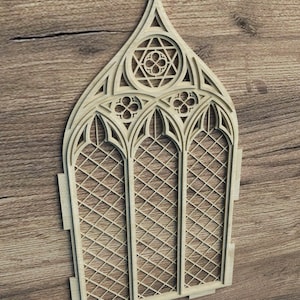 Puede incluir: Un recorte de madera de una ventana de arco gótico con un patrón de diamante. La ventana tiene una parte superior puntiaguda y está decorada con detalles intrincados.