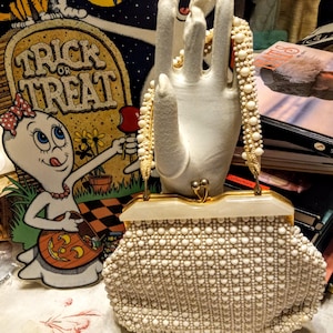 Bolso de mano vintage de los años 50, de plástico blanco con cuentas de imitación de nácar, con asa superior, de 19,5 cm de profundidad y 24,5 cm de ancho, forrado con un bolsillo interior para monedas.