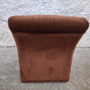 May include: A brown corduroy armchair with a rounded back and a wide, comfortable seat.