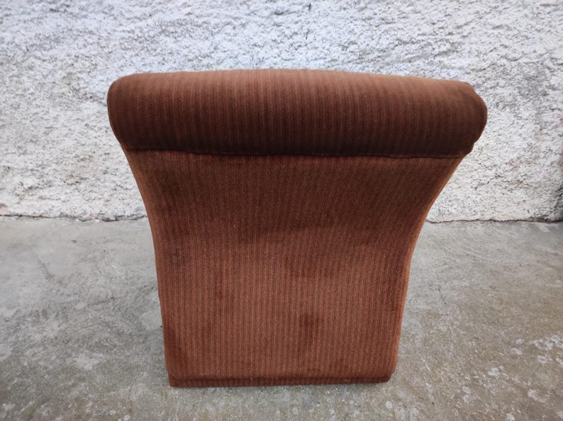 May include: A brown corduroy armchair with a rounded back and a wide, comfortable seat.