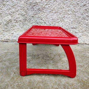 K&ouml;nnte beinhalten: Kleiner, rechteckiger Tisch in leuchtendem Rot mit strukturierter Oberfl&auml;che. Der Tisch hat ein einzigartiges Design mit gebogenen Beinen und misst ca. 46 cm lang, 30 cm breit und 20 cm hoch.